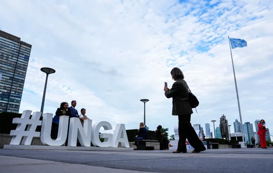 Visitors gather outside United Nations headquarters in New York near the #UNGA sign and U.N. flag during the General Assembly